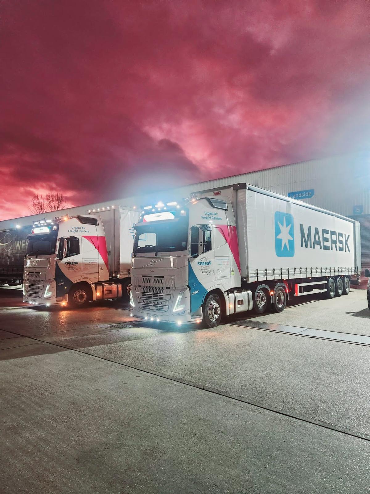 Xpress trucks operating through the night beneath a dramatic sky